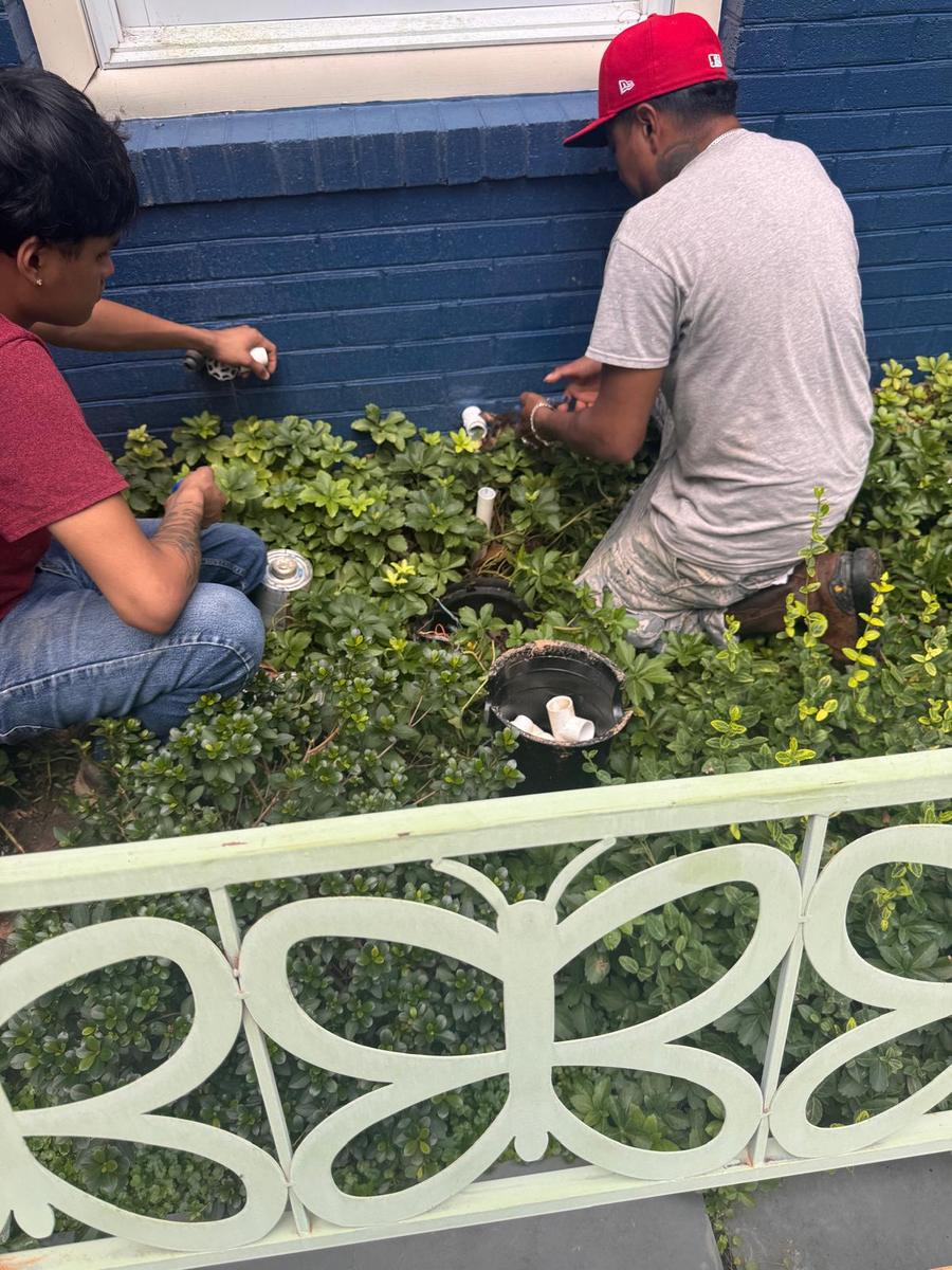 Technicians installing a valve assembly in a planting bed